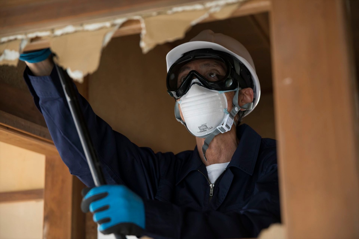 壁の解体作業を進める職人